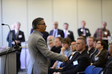 An individual giving a speech to a group of individuals at an Innovation Factory event