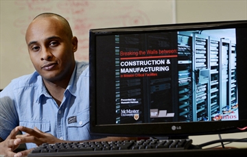 An individual sitting behind a computer screen showing off a presentation on Construction and Manufacturing