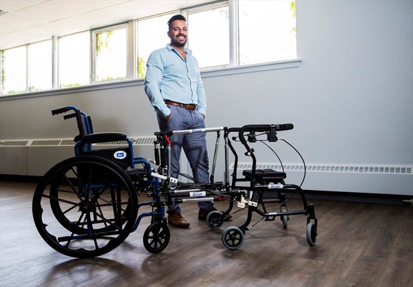 Daniel Bordenave of Bisep Inc., the winner of the 2020 Synapse Life Science pitch competition standing beside a wheelchair with a device connecting it to a walker