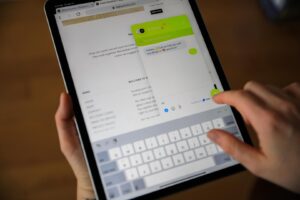 An individual holding an iPad looking at the live chat feature on Digby Paints website