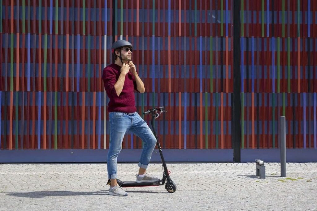 Janik Lipke of Pixabay putting on a helmet before riding an electric scooter