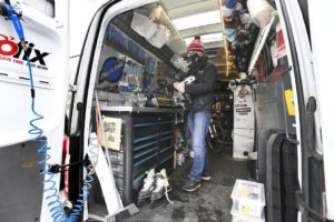 Sean Green, owner and head mechanic of a mobile skate sharpening business in the back of a van sharpening a pair of hockey skates