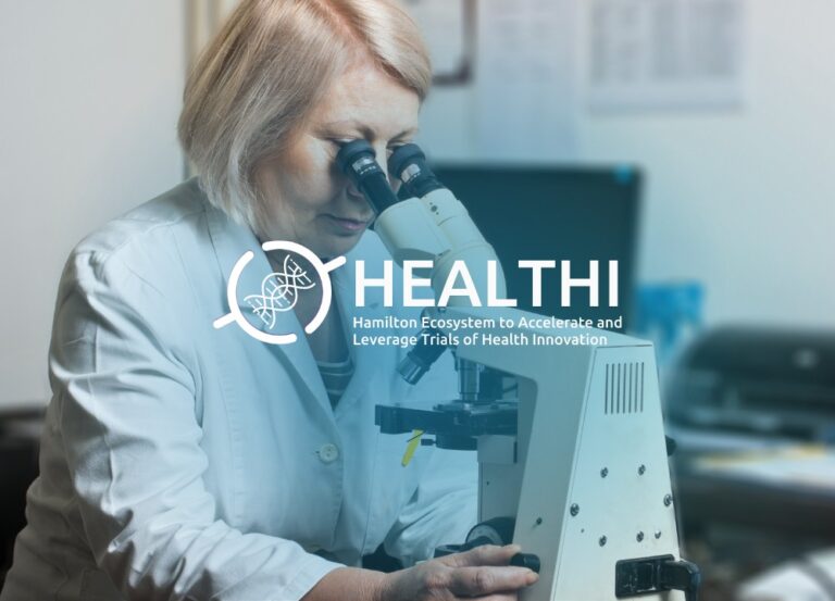 HEALTHI program delivered in partnership by Innovation Factory and Synapse Life Science Consortium. Photo of blonde woman wearing a lab coat looking at microscope.