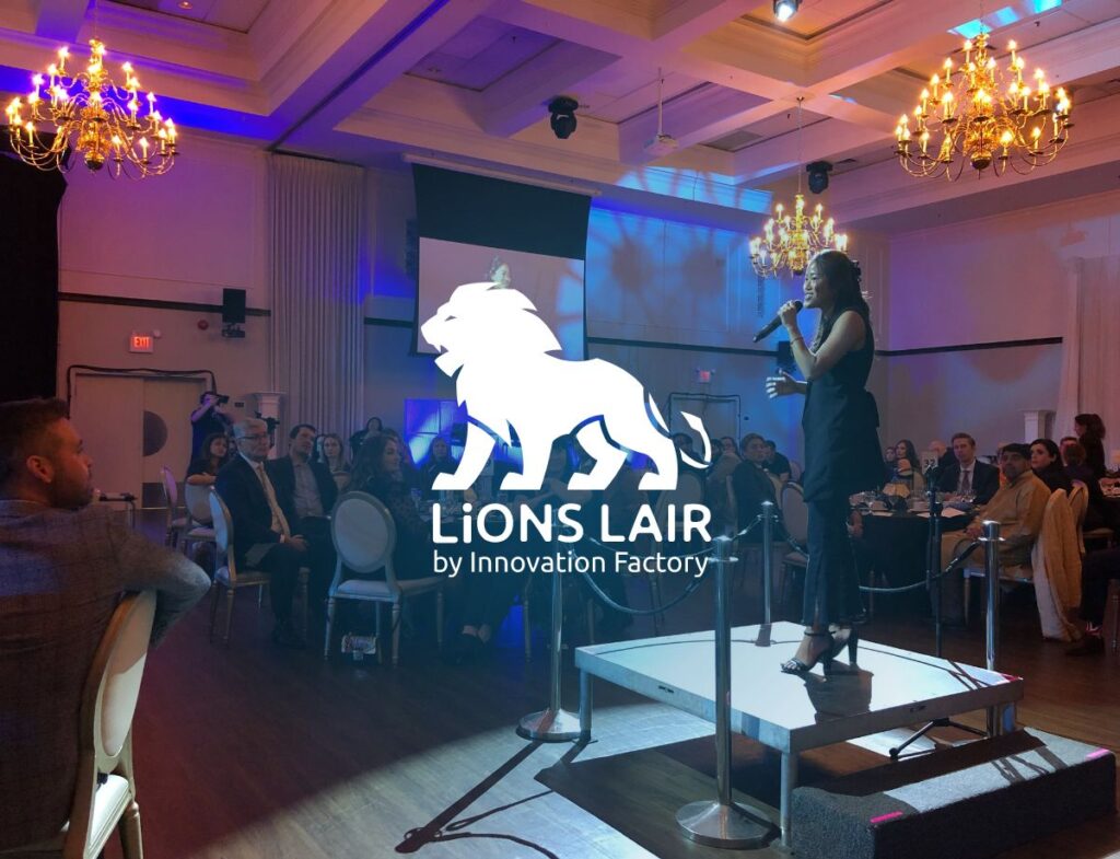 An innovator standing on a podium while pitching at Innovation Factory's signature gala event, LiONS LAIR