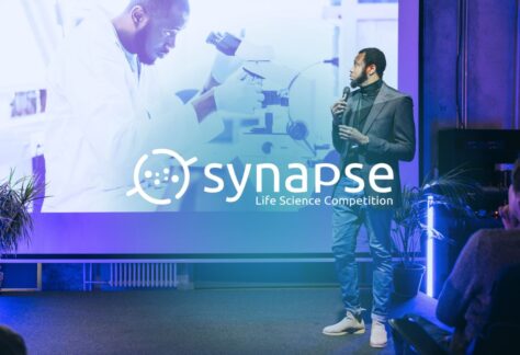 An individual pitching on stage at the Synapse Life Science Competition, an annual competition hosted by Innovation Factory