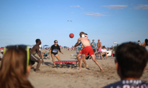 A team of four individuals playing Boardball on the beach