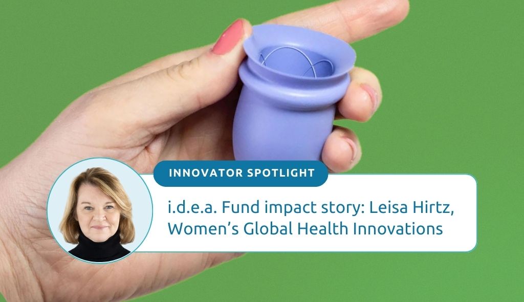 Photo of a hand holding a periwinkle Bfree cup, a menstrual silicone cup designed by Women's Global Health Innovations