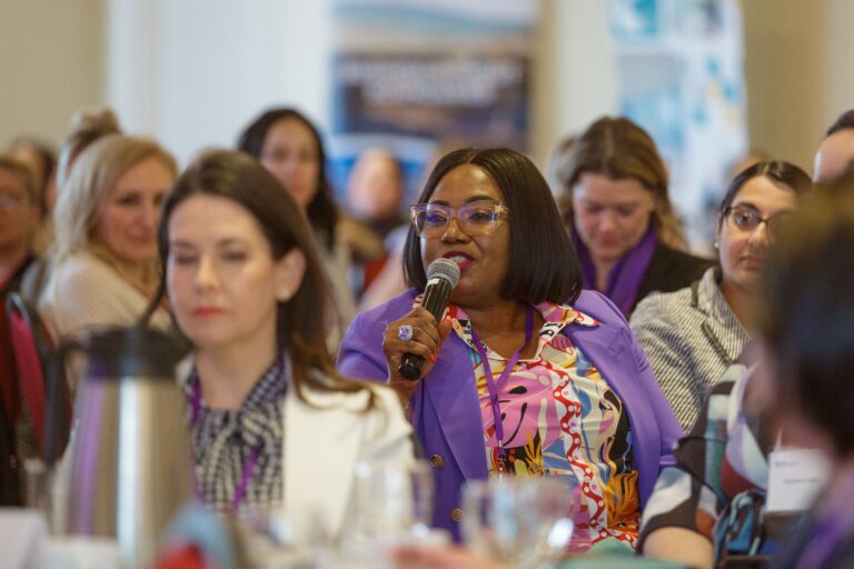 A woman sitting in the crowd during the 2023 HERhalton event asking a question to the speaker